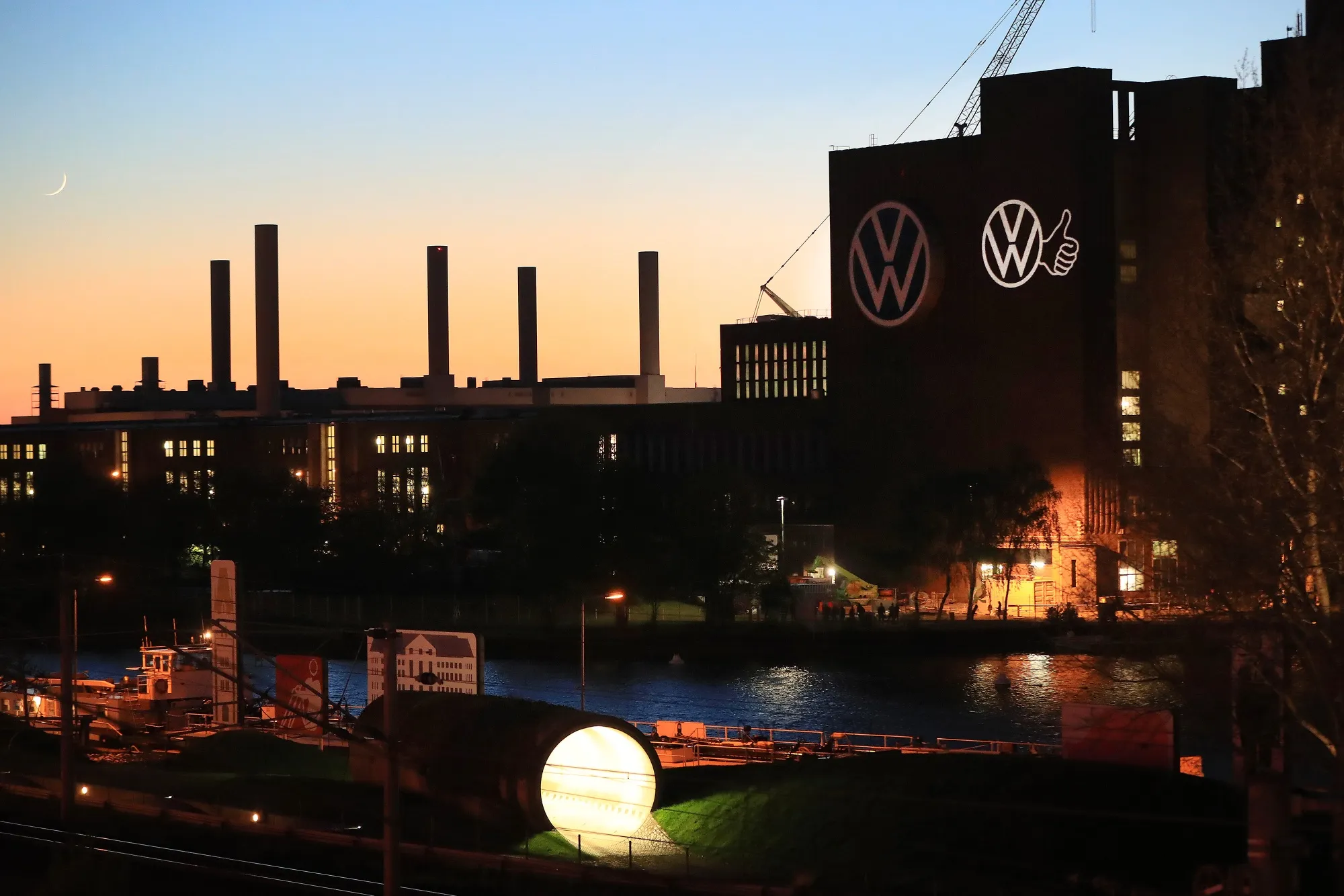 The Volkswagen AG (VW) logo and a 'Thumbs Up' sign illuminate the facade of the VW headquarters ahead of the restart in Wolfsburg, on April 24.