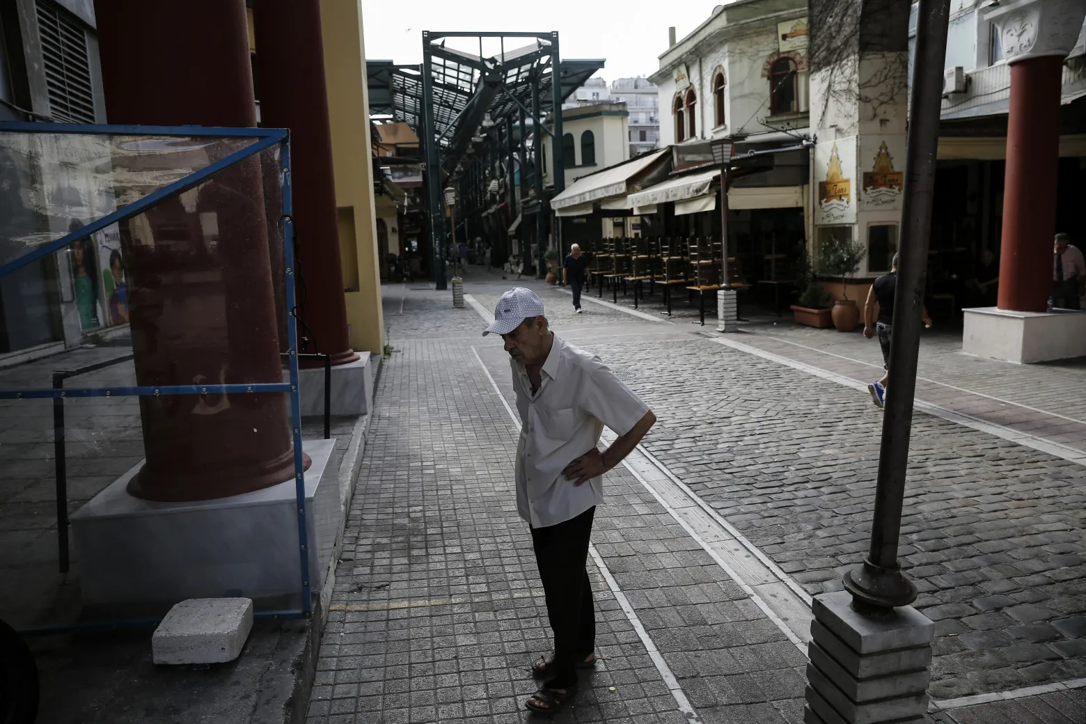 An elderly man walks through an empty street in central Thessaloniki, Greece.
