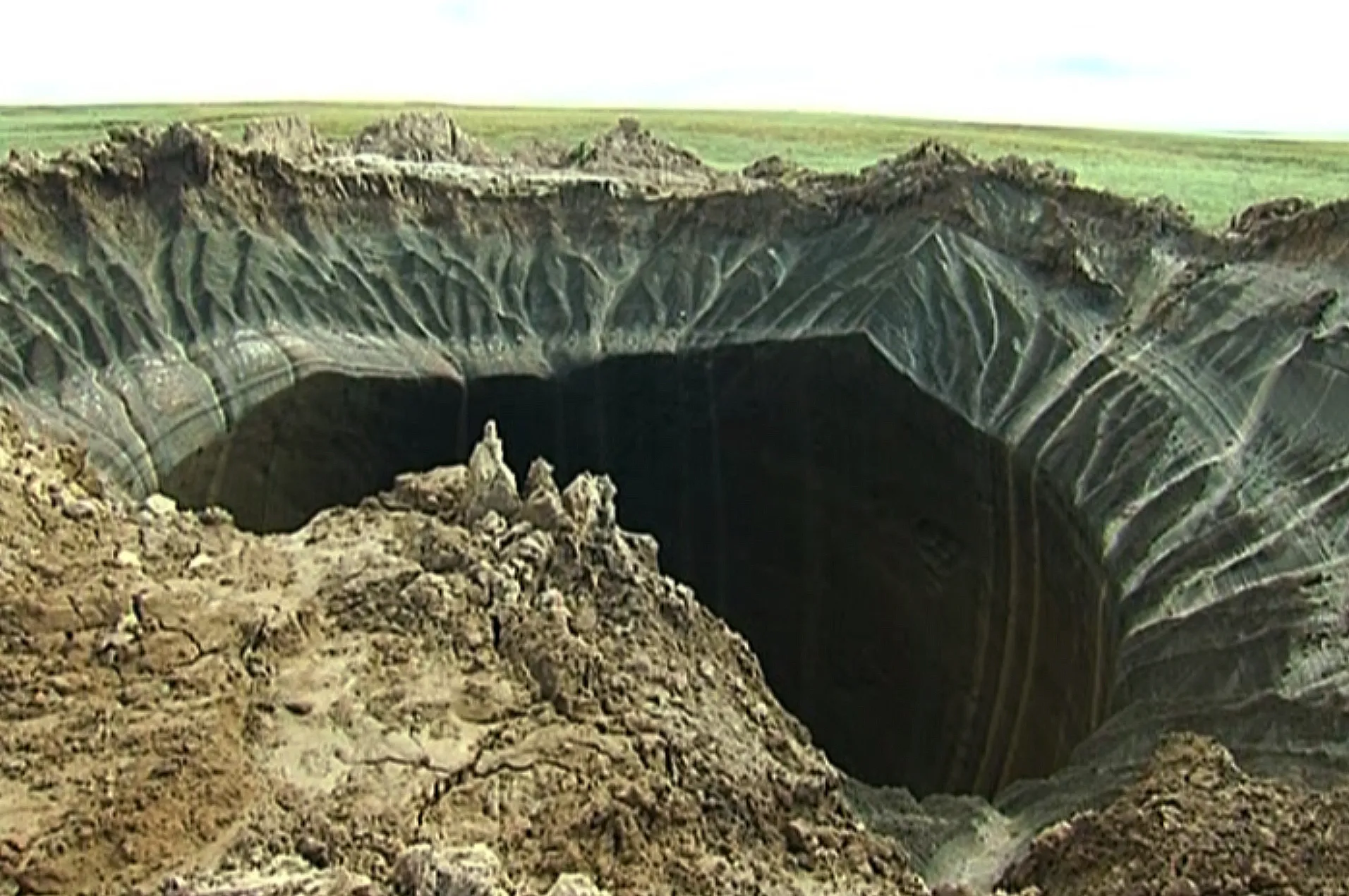 Russian scientists said Thursday July 17, 2014 that they believe a 60-meter wide crater, discovered recently in far northern Siberia, could be the result of changing temperatures in the region. Andrei Plekhanov, a senior researcher at the Scientific Research Center of the Arctic, traveled to the crater. Plekhanov said 80 percent of the crater appeared to be made up of ice and that there were no traces of an explosion, eliminating the possibility that a meteorite had struck the region. Photgrapher: Associated Press Television/AP Photo
