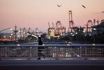 A man walks on a pedestrian overpass at dusk at the Nagoya Port in Nagoya, Japan.