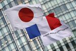 The national flag of Japan, left, flies alongside the national flag of France, center, and a Nissan Motor Co. branded flag outside the Nissan headquarters in Yokohama.