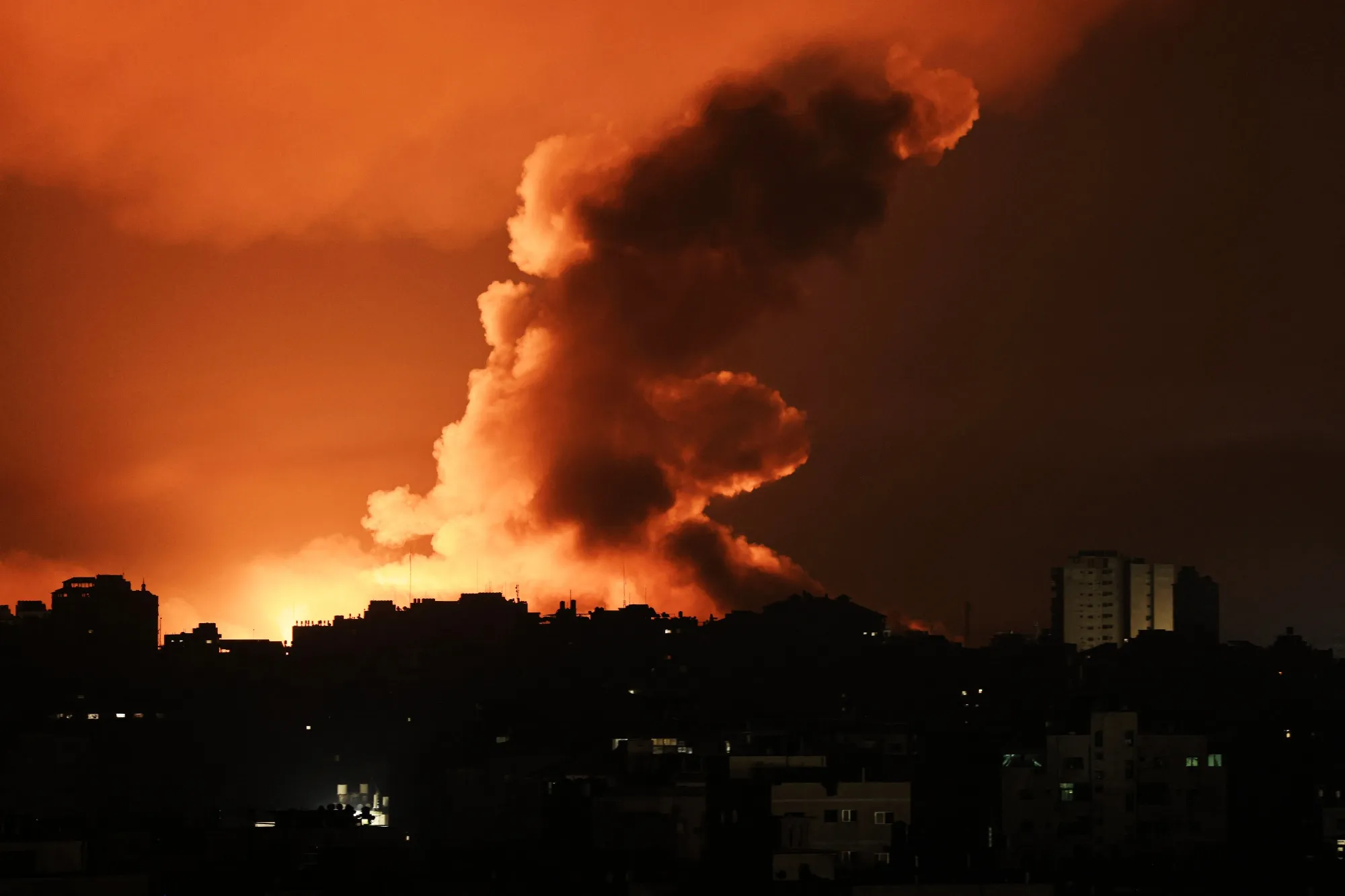 Fire and smoke rise above buildings in Gaza City during an Israeli air strike, on Oct. 13.&nbsp;