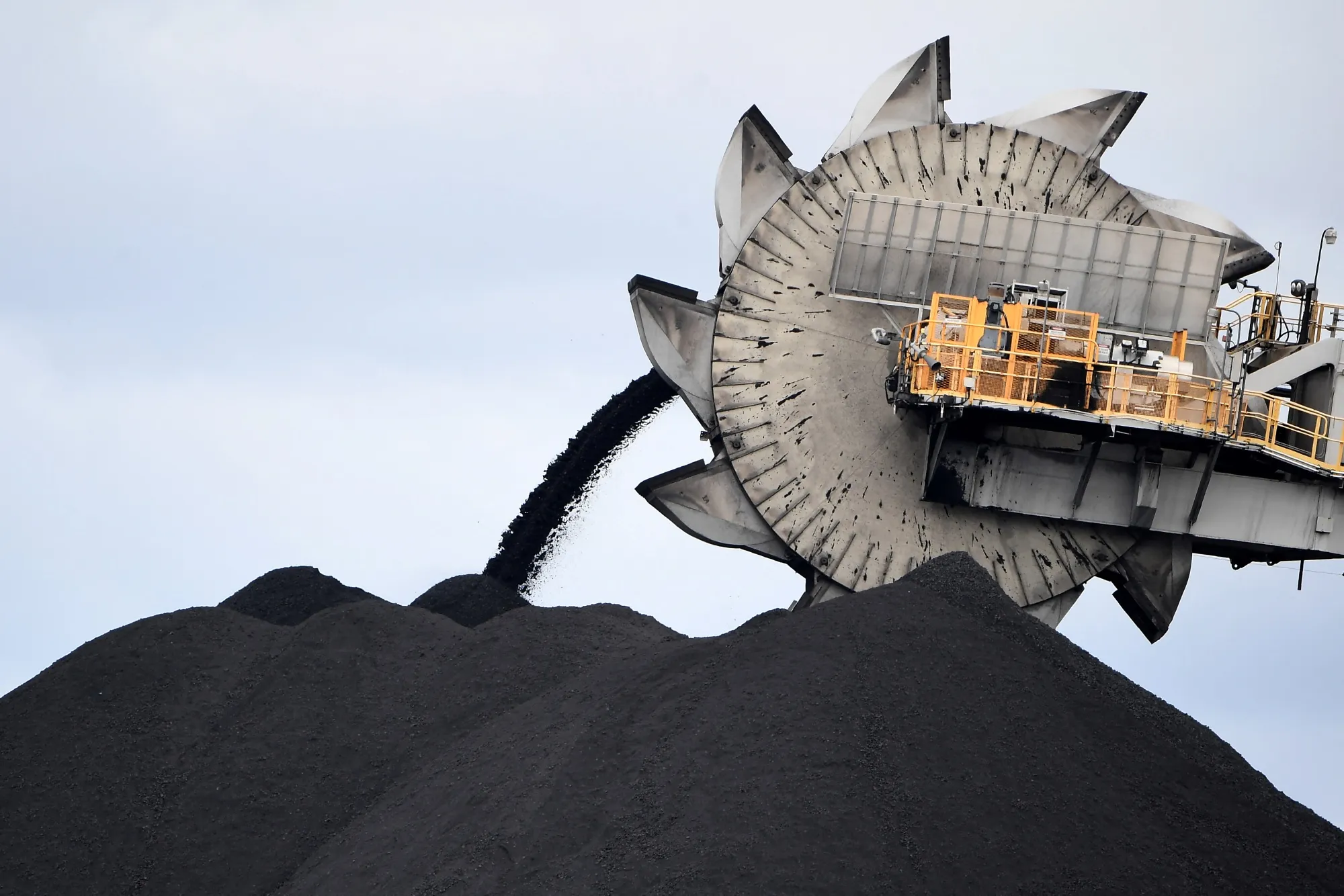 A bucket-wheel dumps soil and sand at a coal mine in Newcastle, Australia.