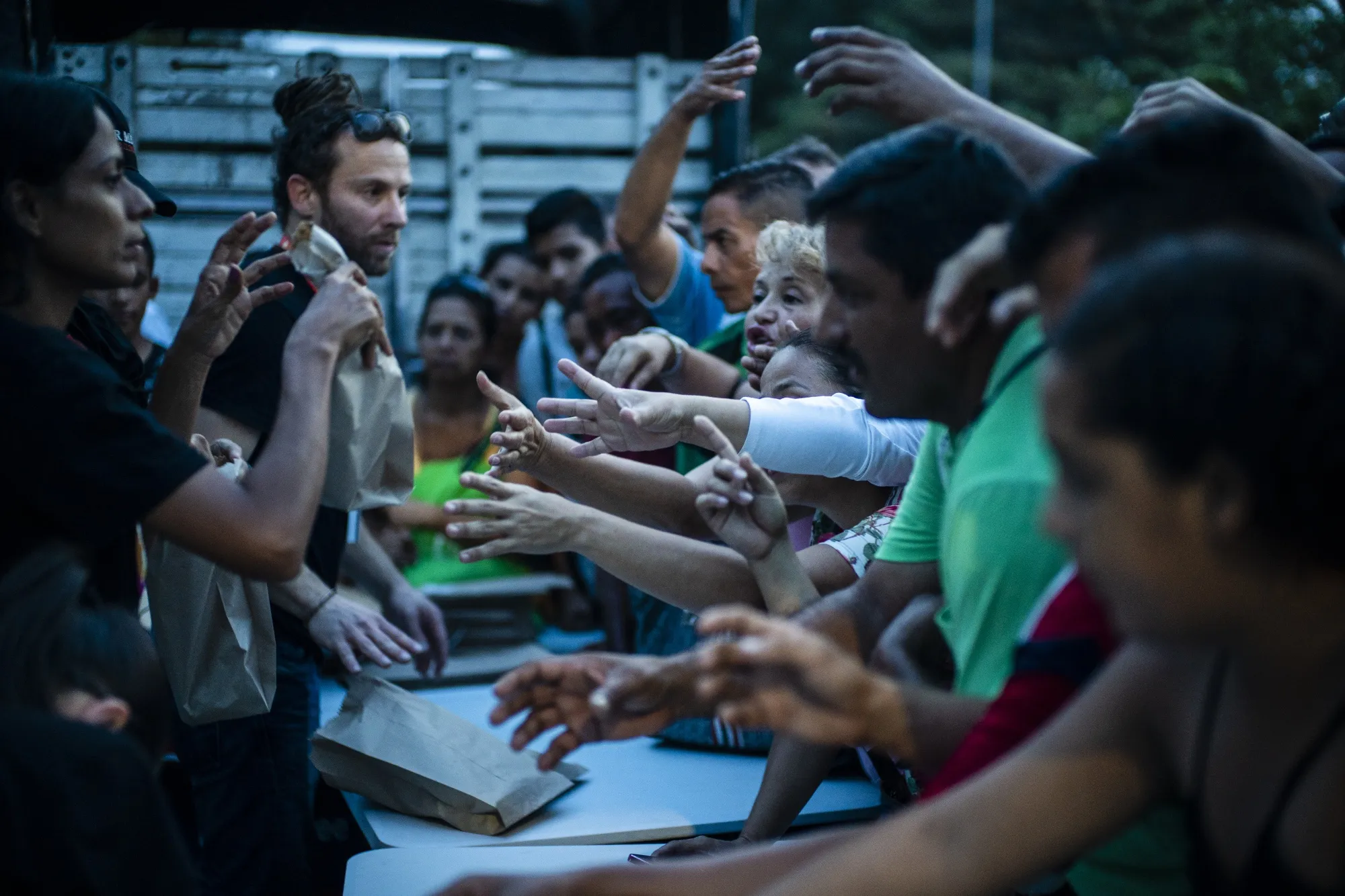 Volunteers, left, distribute food at the Francisco de Paula Santander International Bridge in Cucuta, Colombia, on Feb. 21, 2019.