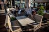Workers clean the outdoor seating area of a restaurant, that may serve a reduced capacity of diners outside, in Lloret de Mar, Spain, on May 19.