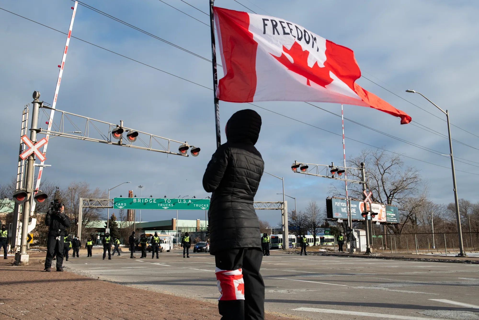A protester&nbsp;holds a Canadian flag as police moved in to clear the demonstration on the Ambassador Bridge in Windsor, Ontario, Canada, on&nbsp;Feb. 12.
