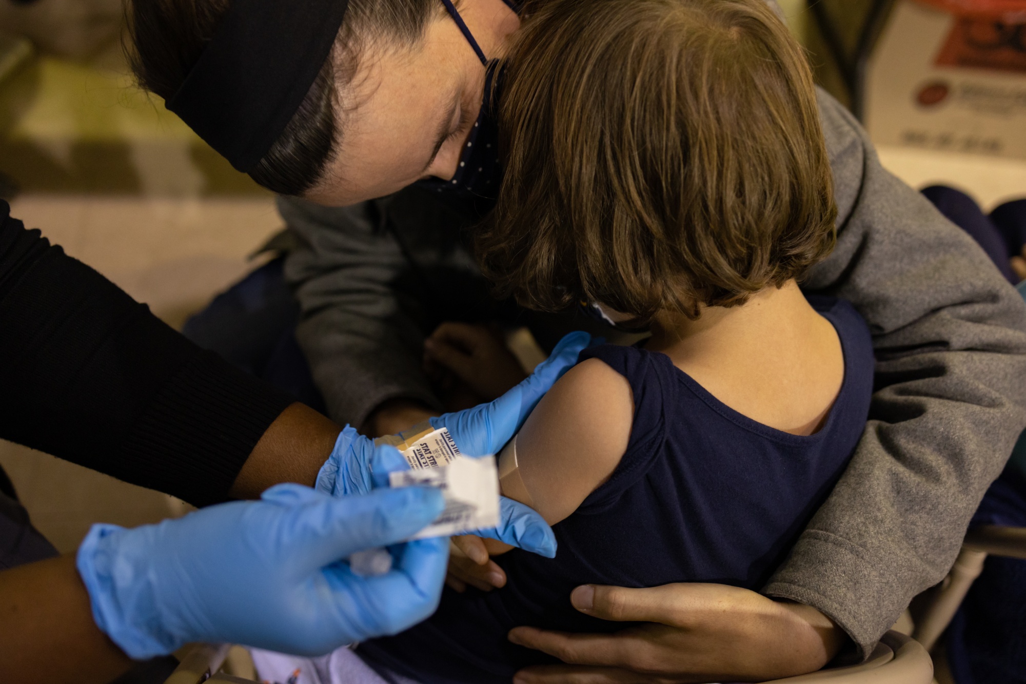 A healthcare worker places a band-aid after administering a dose of the Covid-19 vaccine to a child in Philadelphia, Pennsylvania.