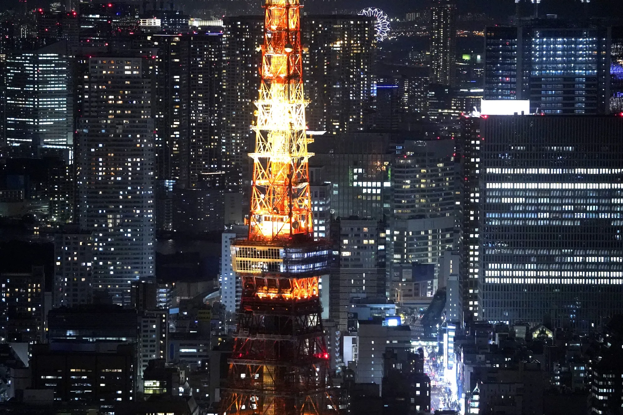 The Tokyo Tower stands illuminated at night in Tokyo.