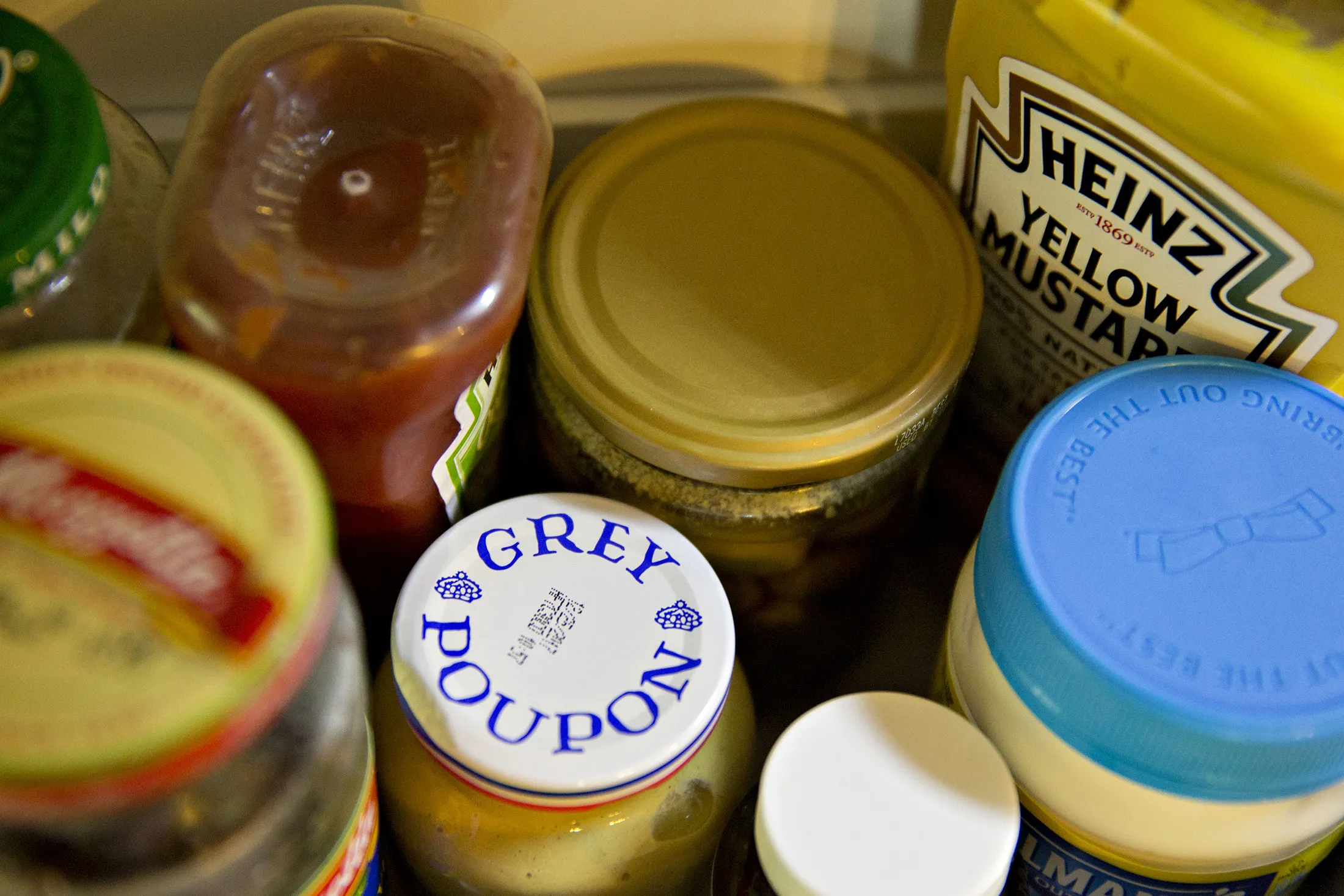 Kraft Heinz Co. Heinz brand ketchup, top second left, mustard, top right, and Grey Poupon brand dijon mustard, bottom second left, are arranged for a photograph in Tiskilwa, Illinois, U.S., on Wednesday, Aug. 2, 2017. Kraft Heinz is scheduled to release earnings figures on August 3.
