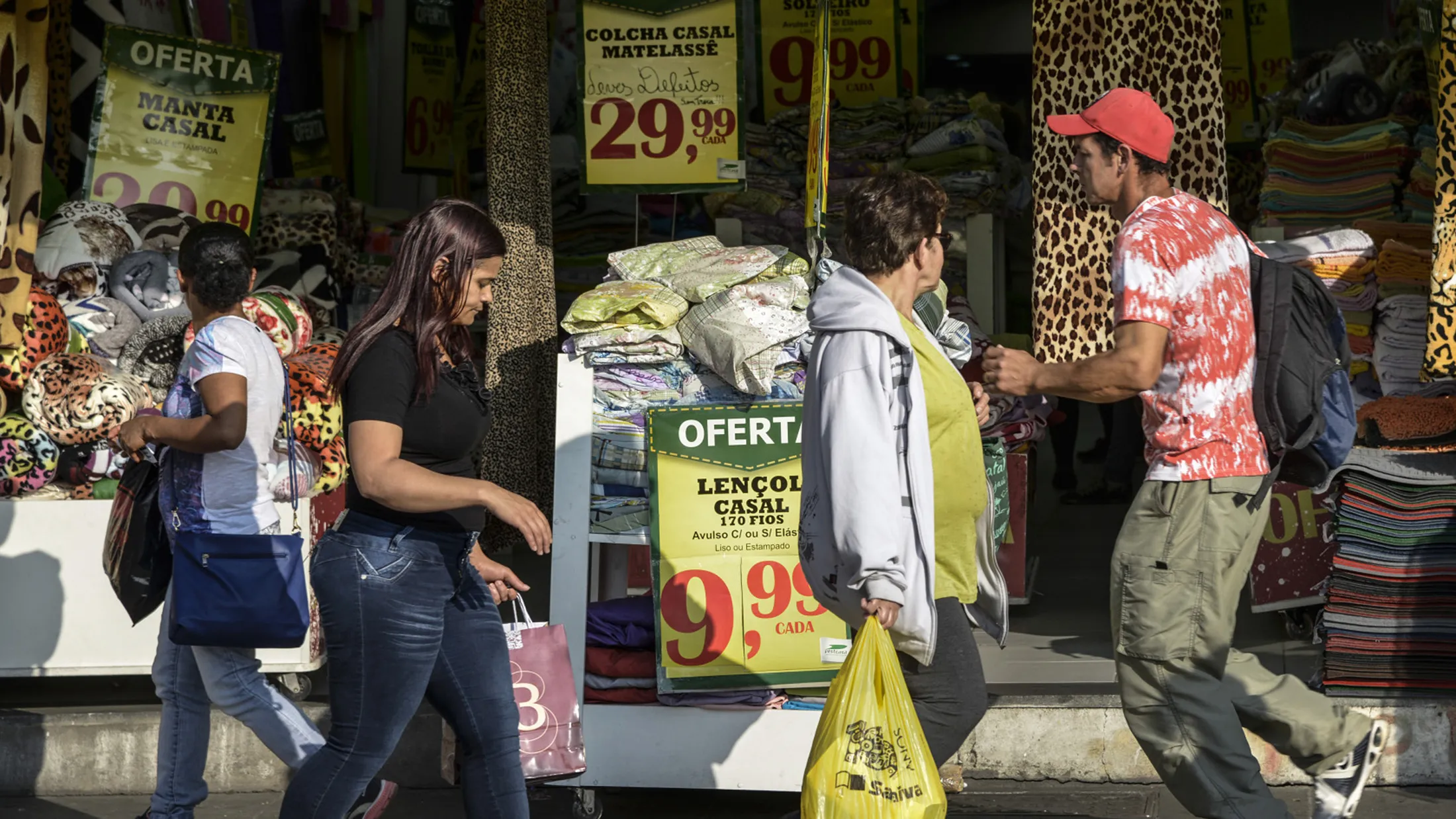People walk past a blanket store in Sao Paulo.
