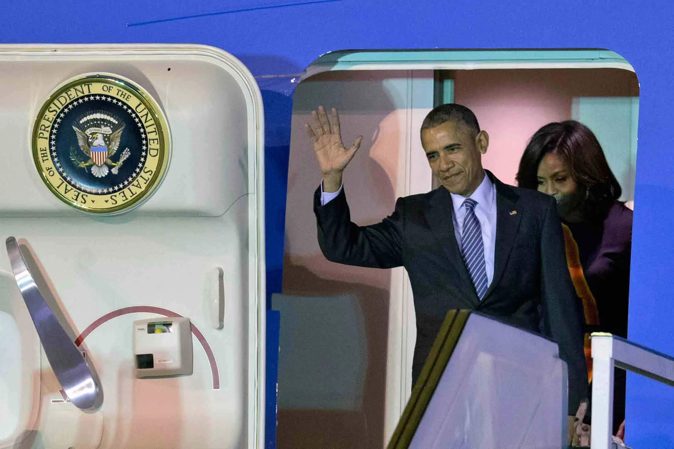 President Barack Obama waves from Air Force One as he arrives with first lady Michelle Obama at the international Buenos Aires airport, Argentina, early Wednesday, March 23, 2016.
