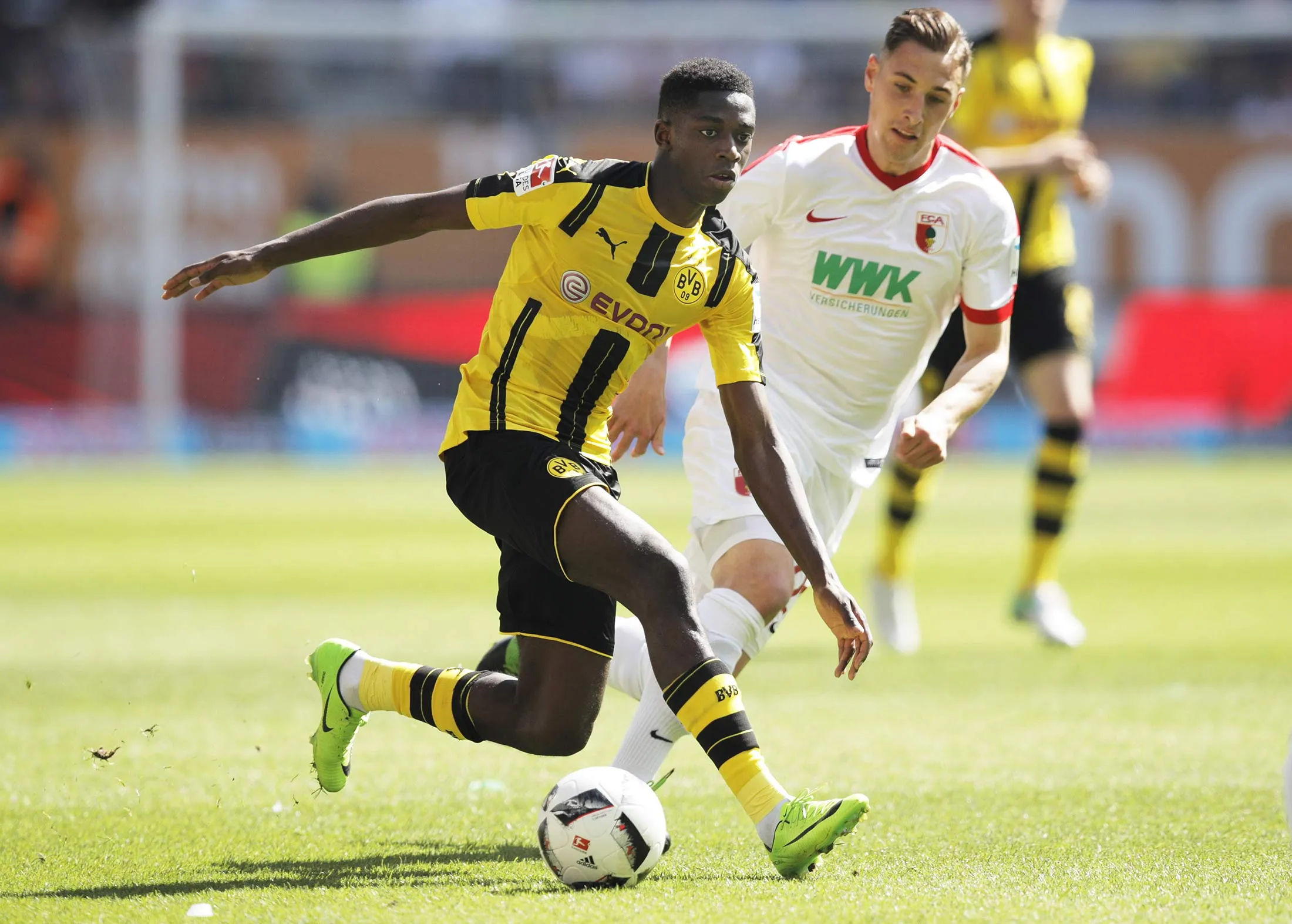 Ousmane Dembele of Borussia Dortmund is challenged by Dominik Kohr of Augsburg during the Bundesliga match between FC Augsburg and Borussia Dortmund at WWK Arena on May 13, 2017 in Augsburg, Germany.
