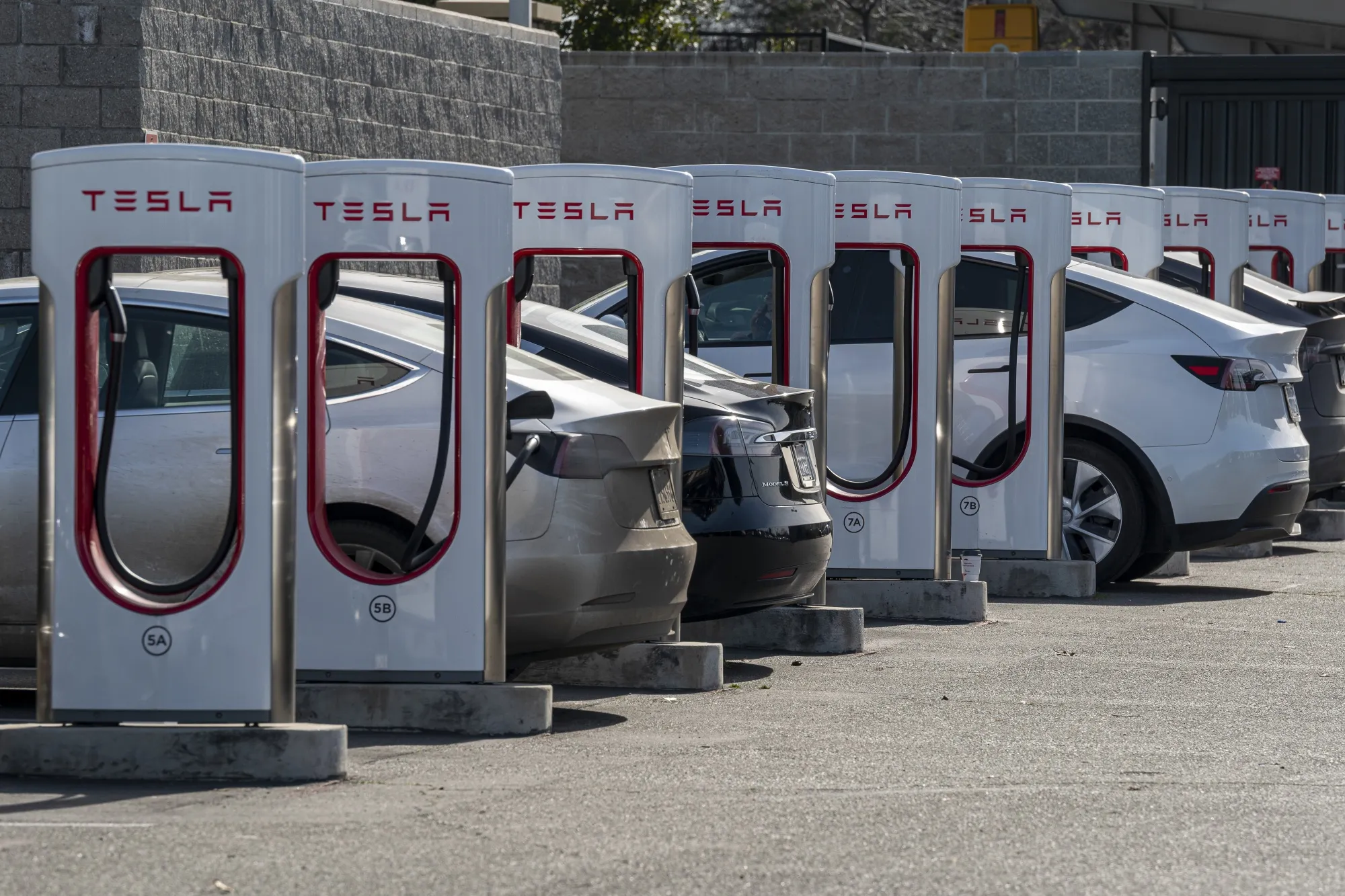 Tesla vehicles at charging stations.