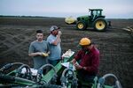 (Left to right) Lane Simmons, his father Chris Simmons, and Carlos Gomez take a late dinner break from tilling and planting fields at Whitaker Farms.