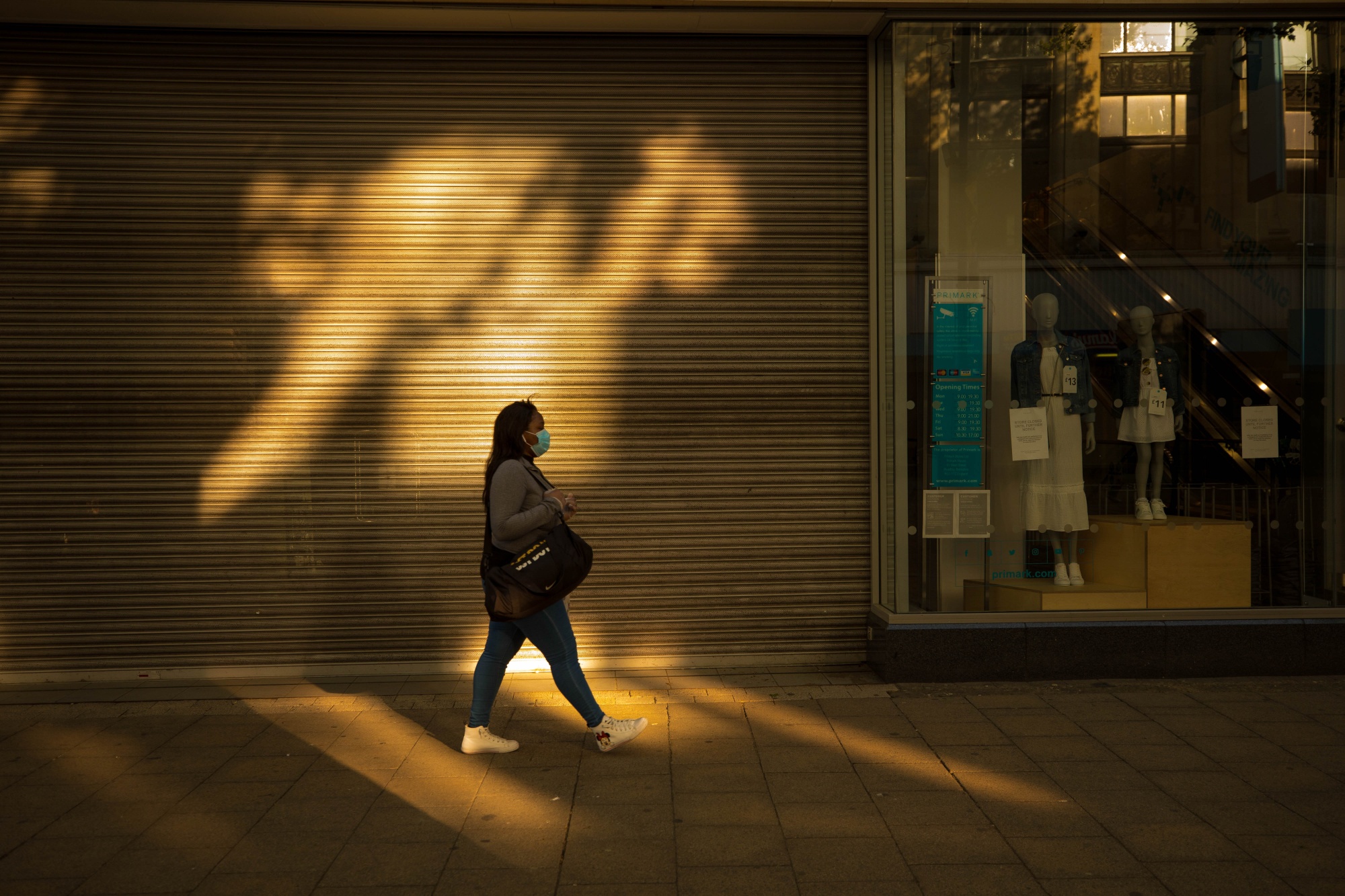 A pedestrian passes the shuttered entrance to a store in Croydon, U.K.