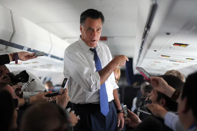 U.S. Republican presidential candidate Mitt Romney talks to journalists on board his campaign plane in September 2012