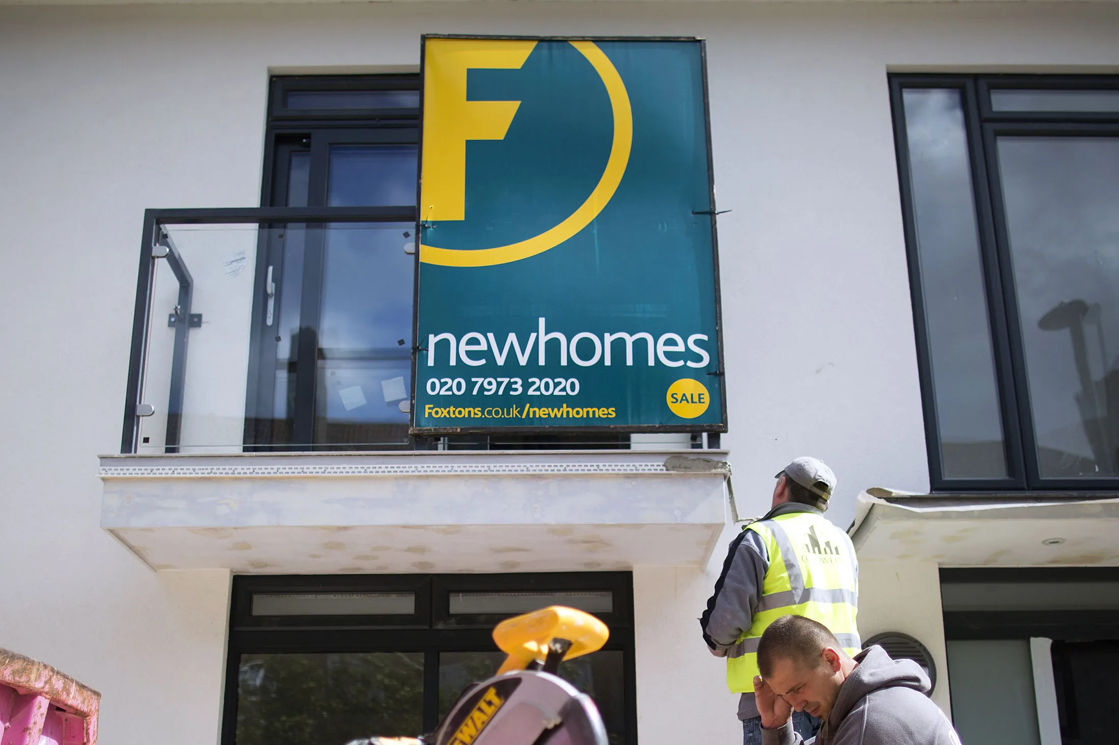 A Foxtons estate agents sign advertises 'New Homes' for sale as builders work during the construction of a new home in the Brixton district of London, U.K., on Monday, May 13, 2013. BC Partners Ltd., owner of real estate broker Foxtons Ltd., plans to appoint bankers this month to look at options for the company, Sky News reported, citing people familiar with the matter.
