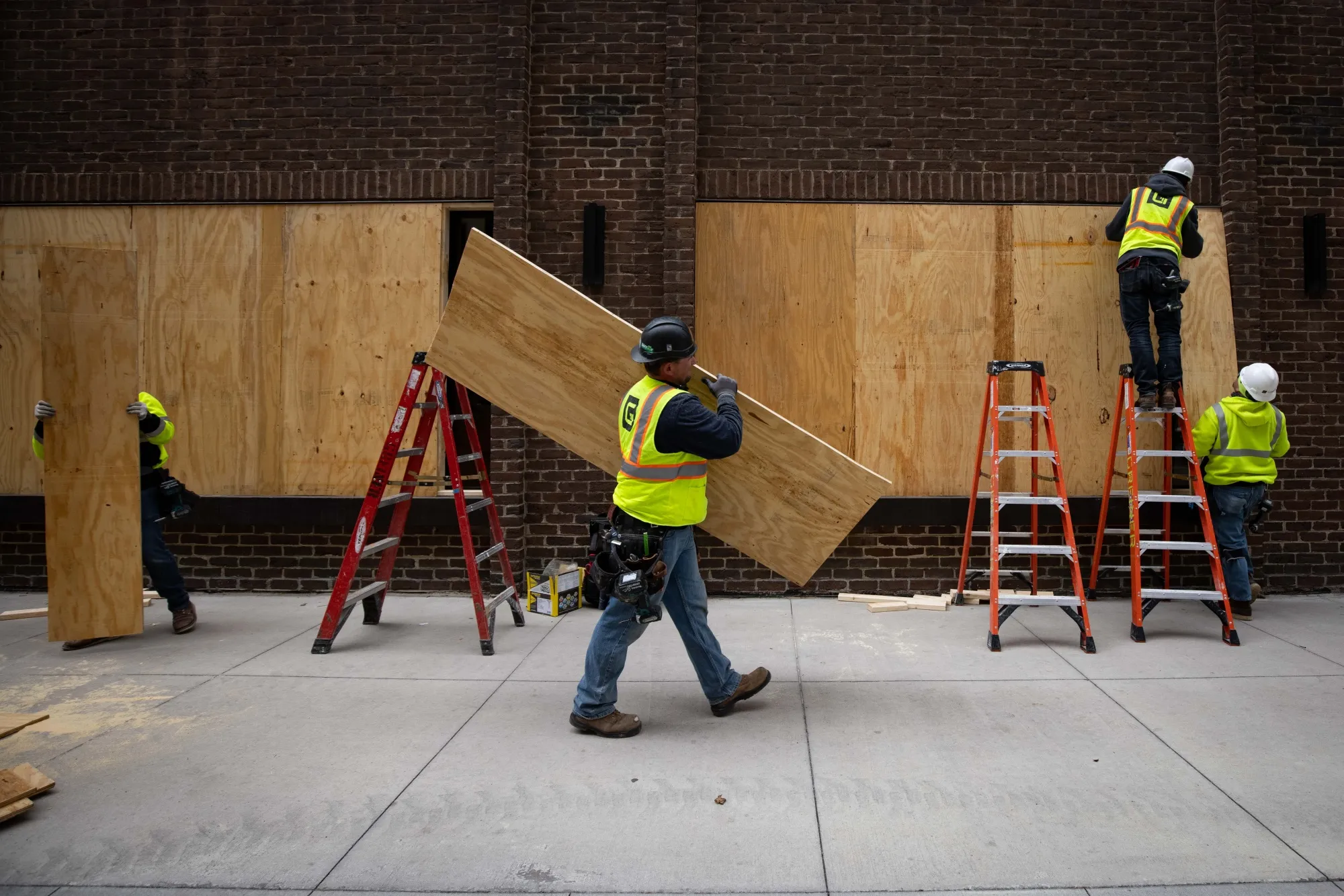 Construction workers board up business near the Hennepin County Government Center in Minneapolis, Minnesota, U.S.