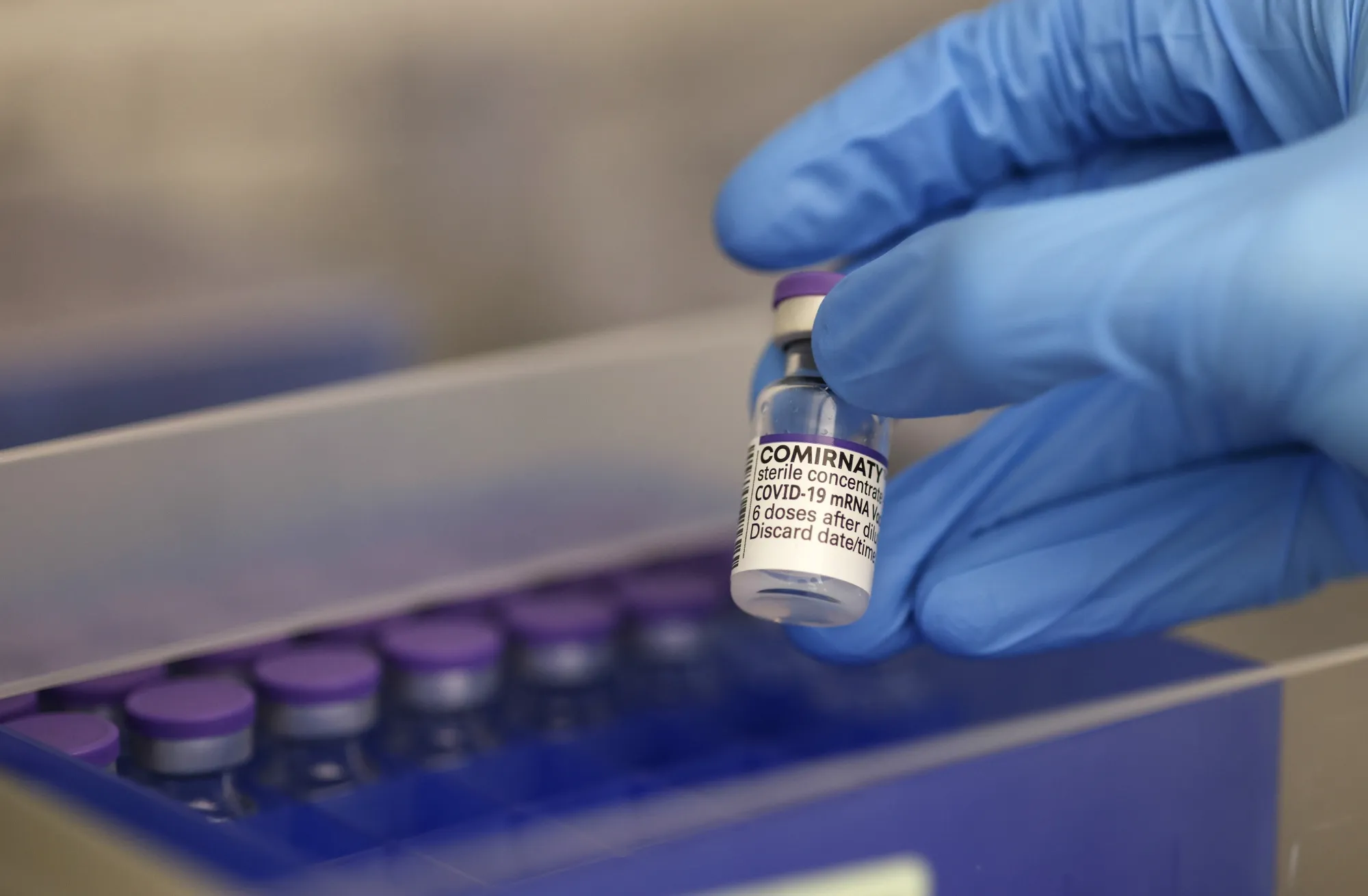 A healthcare worker holds a vial of the Pfizer-BioNTech vaccine for Covid-19.