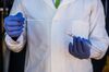 A medical worker displays a sample of a testing swab at a National Health Laboratory Service mobile laboratory in Rustenburg.