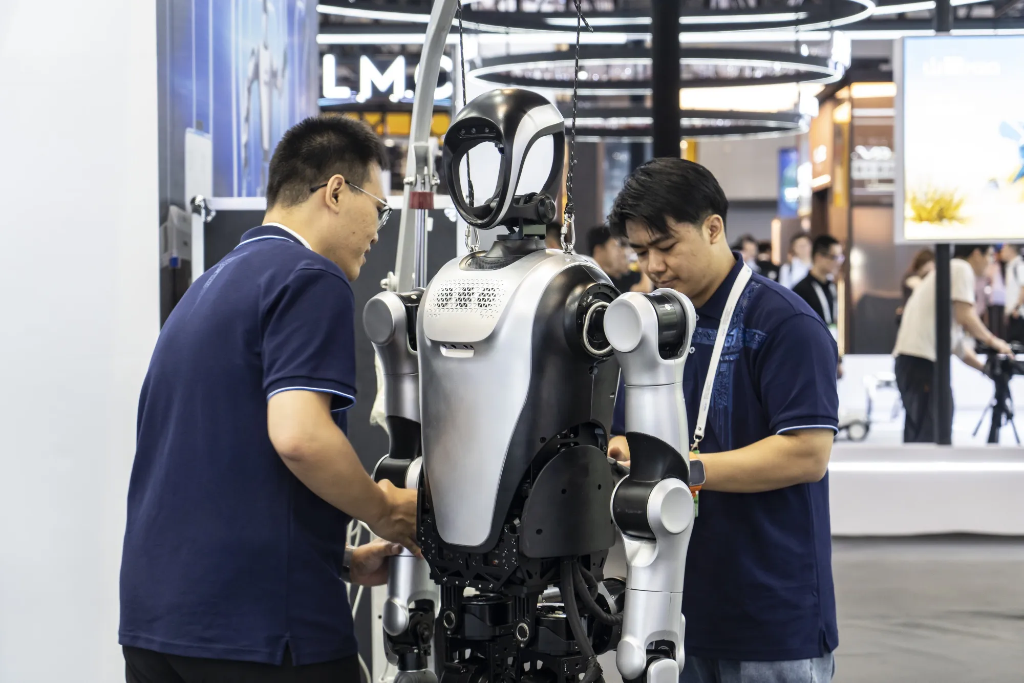 Employees service a Leju Robotics robot at the World Artificial Intelligence Conference in Shanghai.