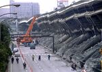 A giant crane pulls crushed cars out of the debris after an expressway was devastated during the 1995 earthquake in Kobe, Japan.