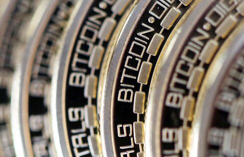 The embossed word Bitcoin sits on the edge of Bitcoins stacked in this arranged photograph in Danbury, U.K.