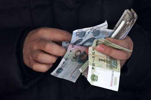 A vendor counts Chinese yuan banknotes in Beijing, China, on March 2, 2015.