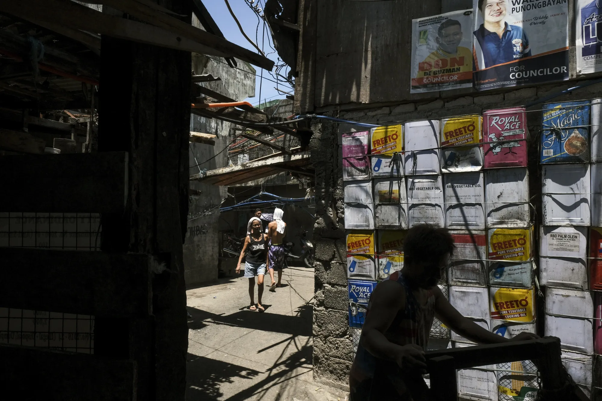 Pedestrians walk through an alleyway in the San Roque neighborhood of Manila.