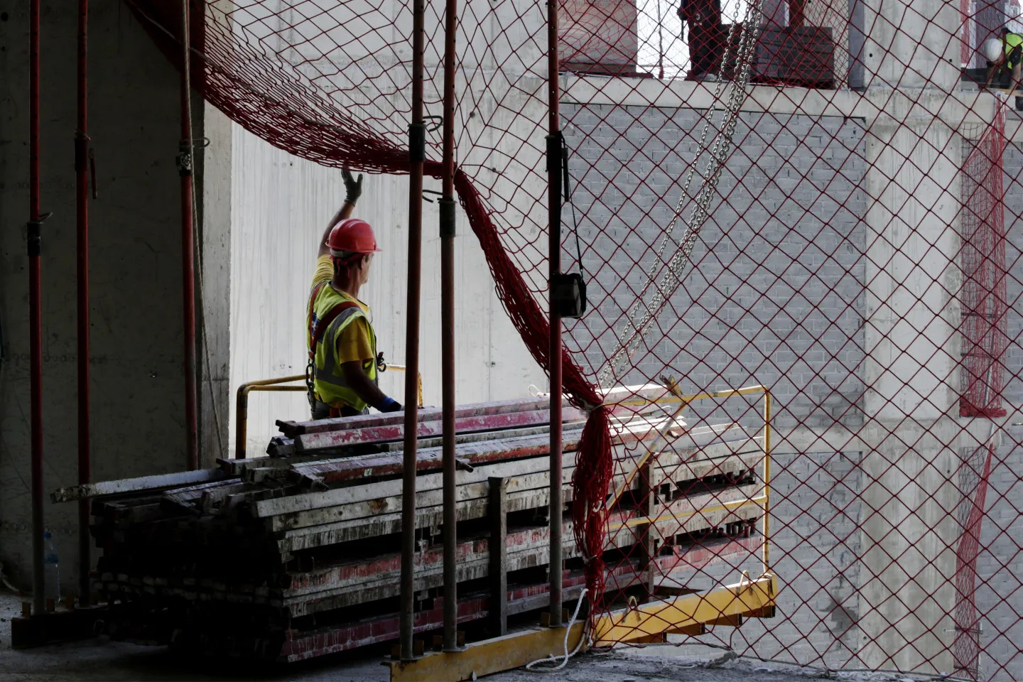 A builder moves steel framework in a building constructed by&nbsp;Sacyr SA in Barcelona, Spain.