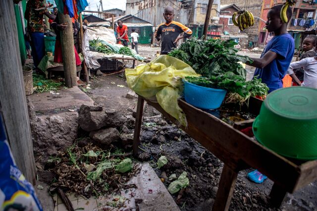 A vegetable farm stall on the same of a street.