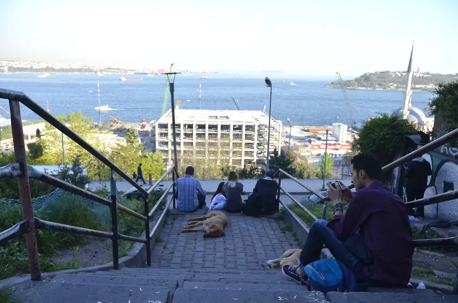 Young people sit on the stairs next to the Roma bostan to take in the view. 