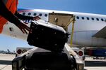 A ground crew member loads baggage onto a Spirit Airlines plane at San Diego International Airport