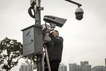 A worker inspects a junction box as Hangzhou Hikvision Digital Technology Co. cameras operate in Chongqing, China.
