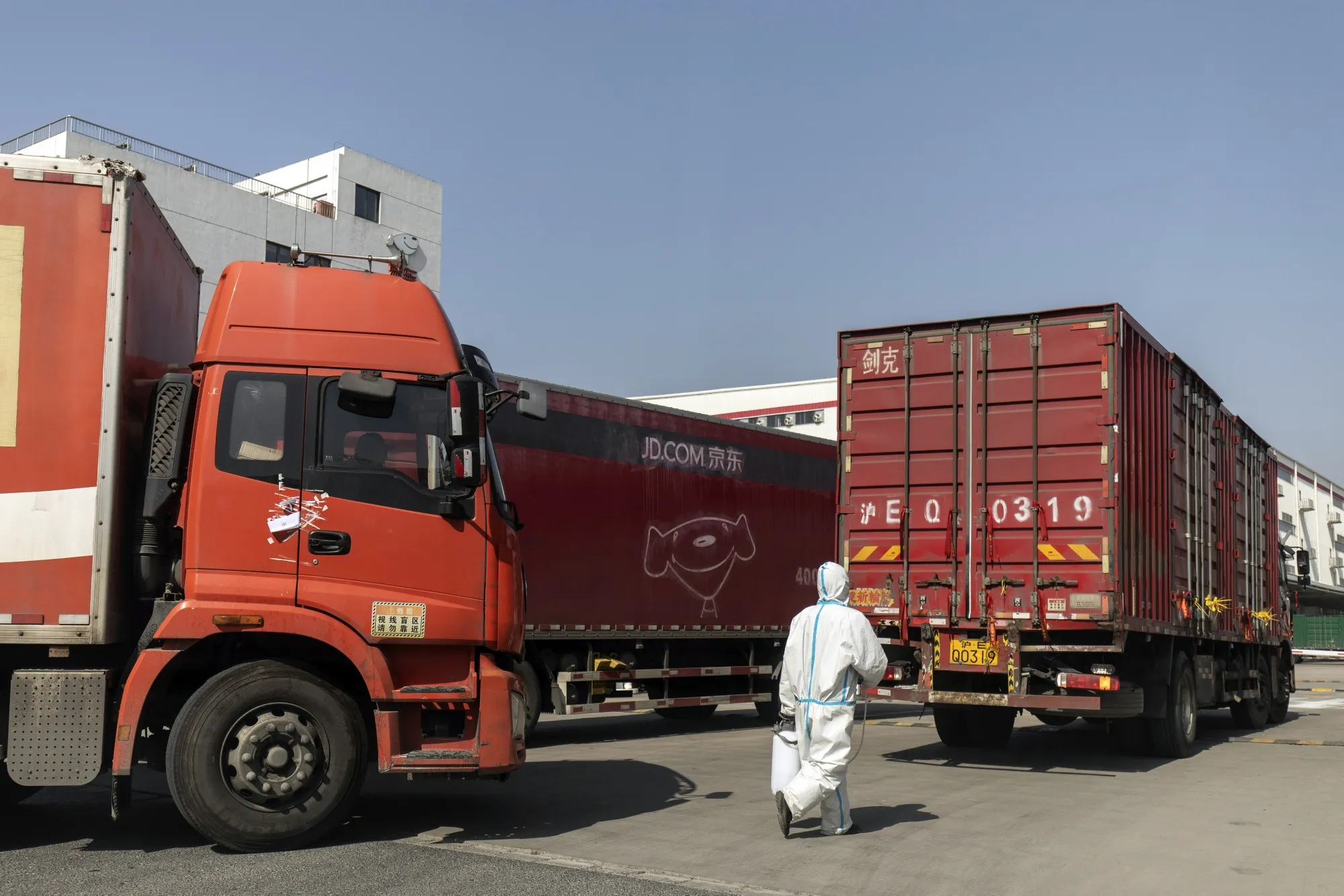 A worker wearing personal protective equipment (PPE) disinfects a truck entering JD.com Inc.'s Asia No. 1 Shanghai Jading Logistics Park facility in Shanghai&nbsp;on March 9.
