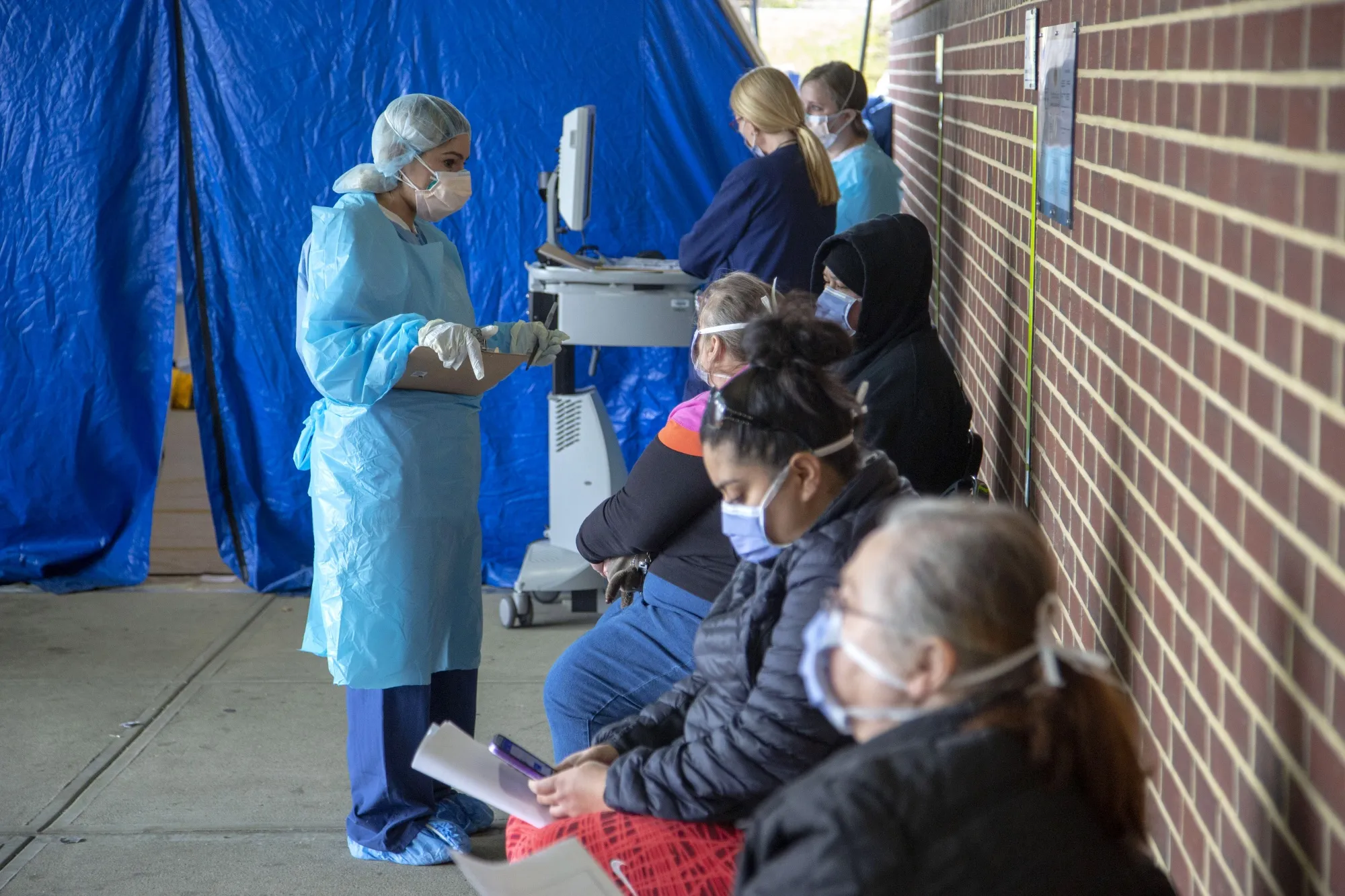 A medical worker speaks to patients outside a tent at the Holy Name Medical Center in Teaneck, New Jersey, on March 17.