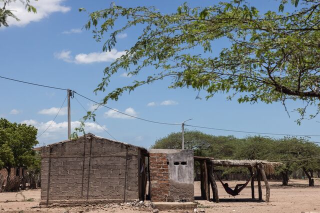 A resident sleeps in a hammock outside a home.