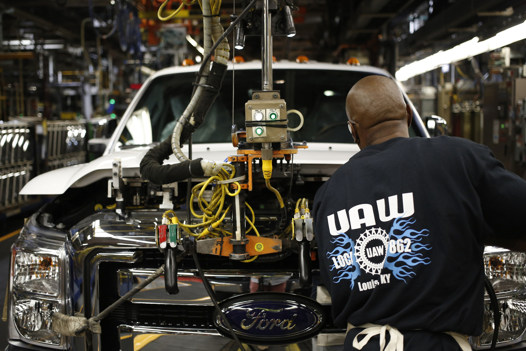 A worker wearing a United Auto Workers (UAW) shirt assembles a Ford Motor Co. Super Duty series pickup truck at the company's truck manufacturing plant in Louisville, Kentucky, U.S.
