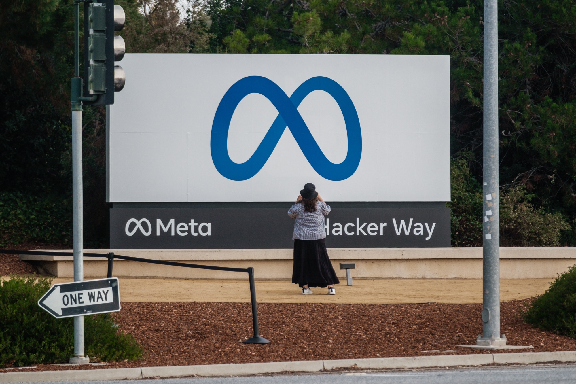 A visitor takes a photograph&nbsp;of the Meta Platforms sign outside the company's headquarters in Menlo Park, California.