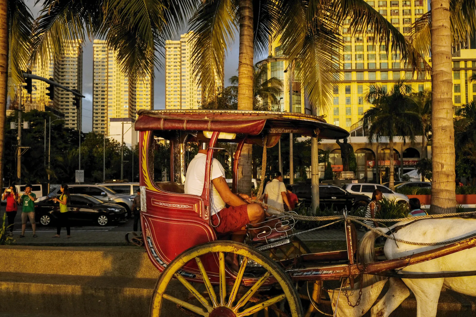 A horse-drawn carriage driver waits for customers on Roxas Boulevard in Manila, Philippines.