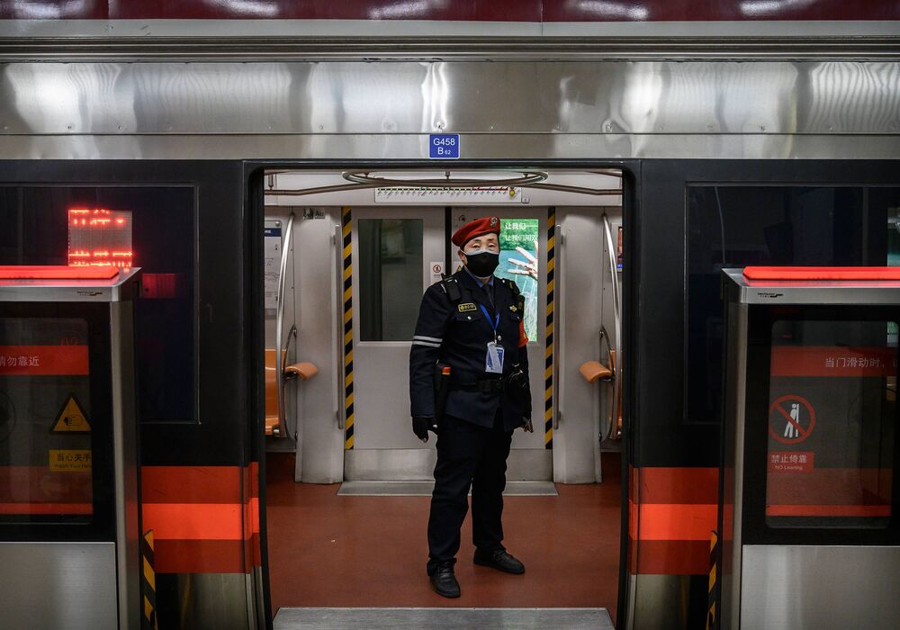 A Chinese security guard wears a protective mask as he stands in a nearly empty subway car during rush hour on February 14, 2020 in Beijing, China.