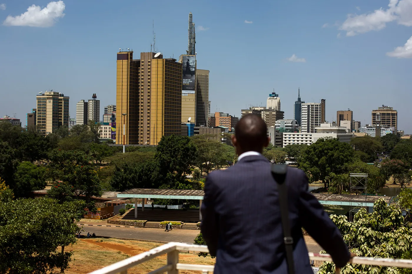A man stands and looks out across the city skyline in Nairobi.