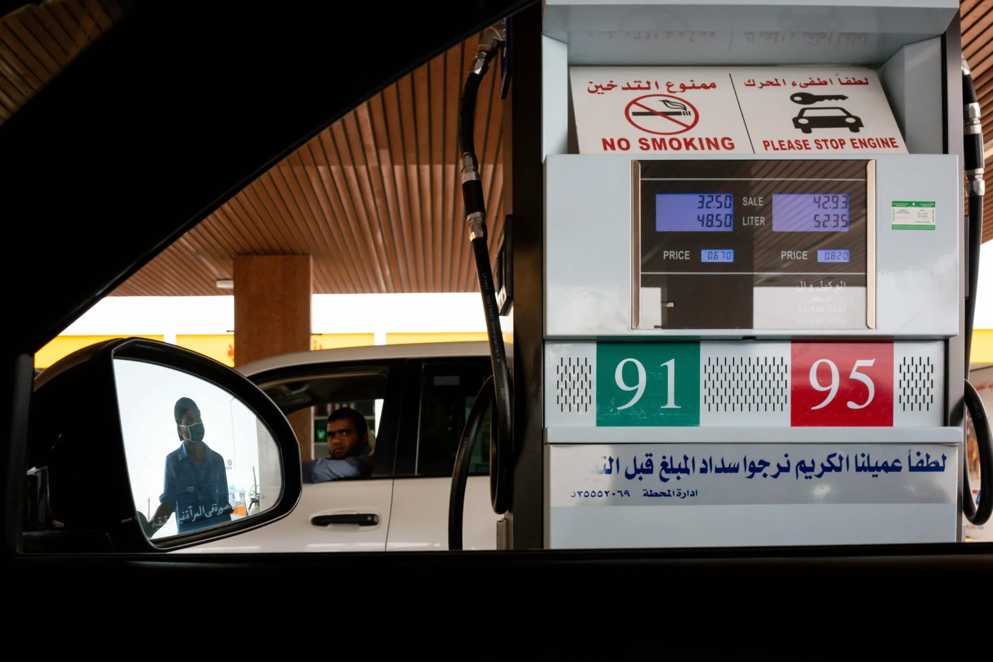 An attendant fills an automobile with fuel at a gas station in Riyadh.