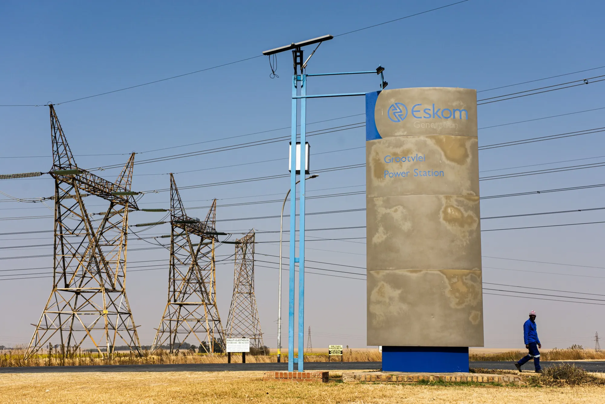 A worker walks along the access road to the Eskom Holdings SOC Ltd. Grootvlei coal-fired power station in Mpumalanga, South Africa.&nbsp;