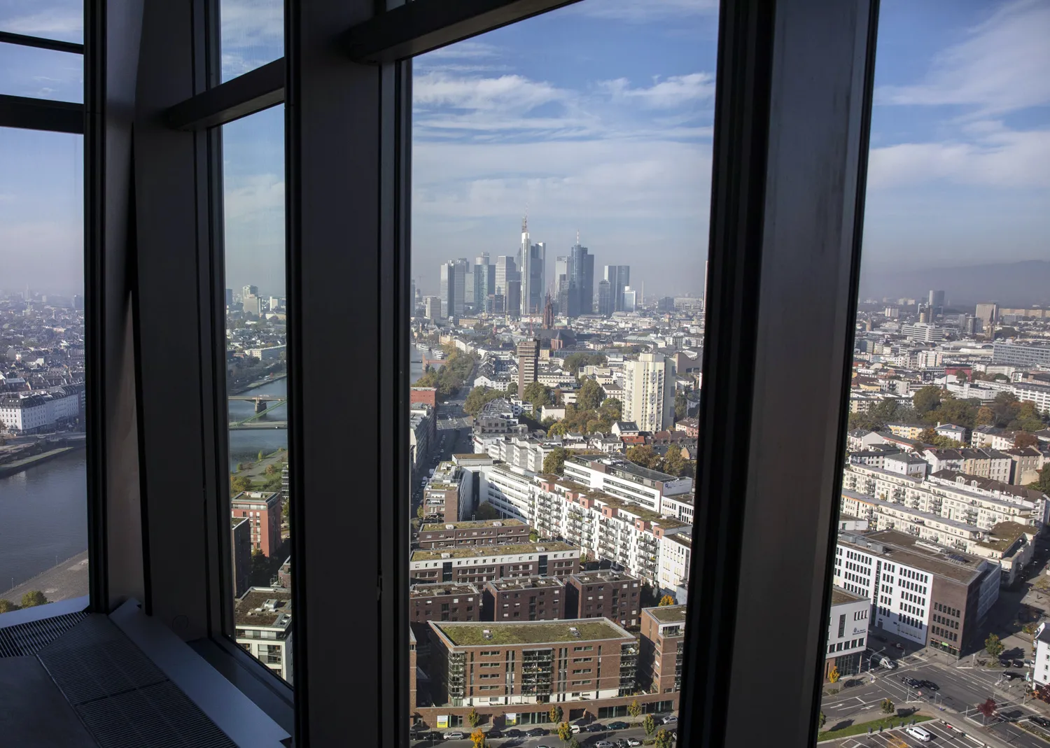 The River Main flows past commercial and residential property as skyscrapers stand in the financial district as the city skyline is seen from the 15th floor pantry area inside the European Central Bank (ECB) headquarters in Frankfurt.