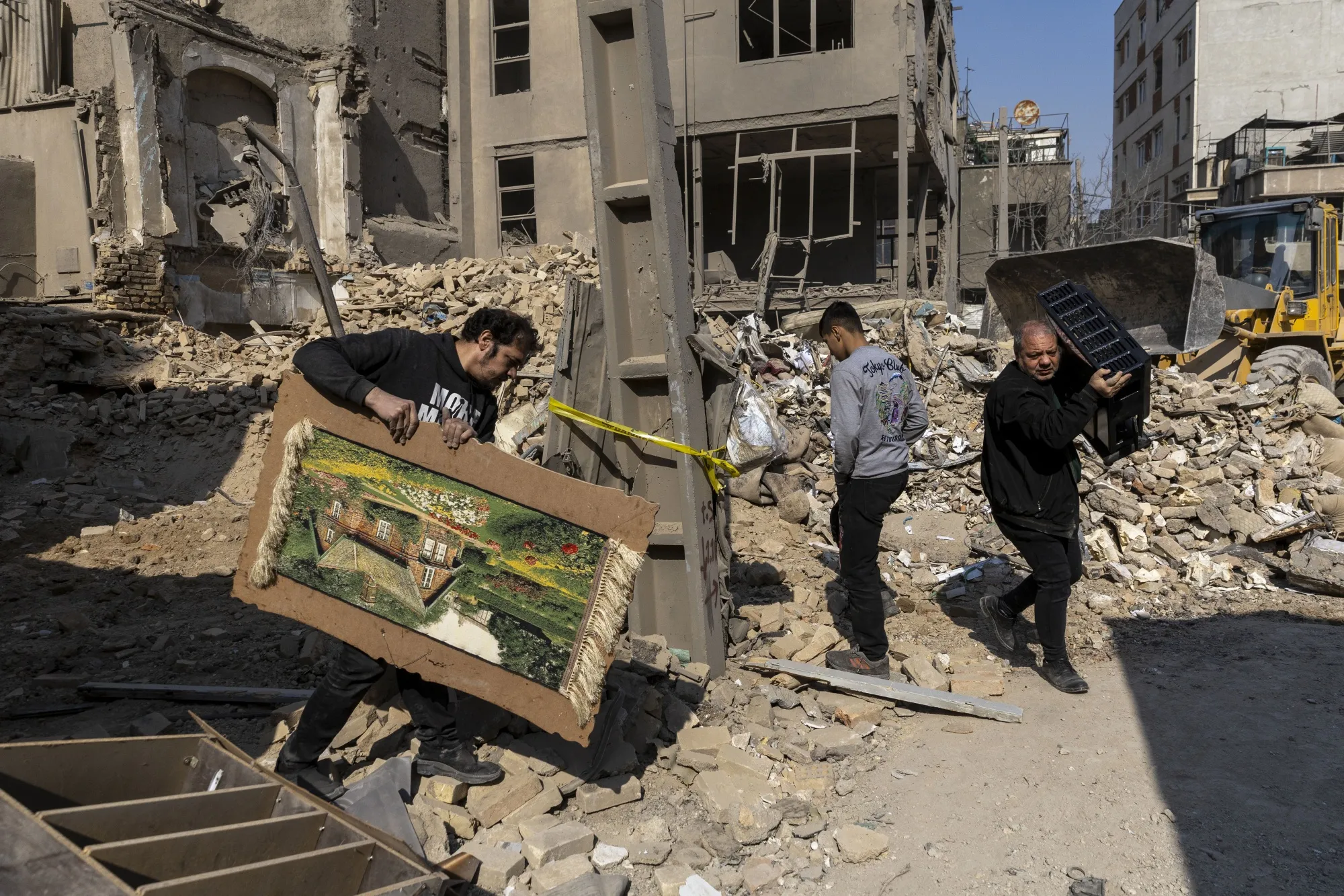 People salvage belongings from&nbsp;destroyed buildings in Tehran on March 14.