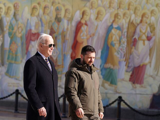 US President Joe Biden (left) walks next to Ukrainian President Volodymyr Zelenskiy (R) as he arrives for a surprise visit to Kyiv on February 20, 2023. They walk past a religious mural at the St. Michaels Golden-Domed Cathedral.