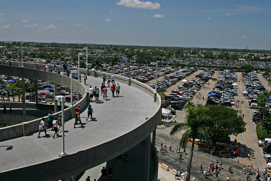 Surrounded by a sea of parking lots, fans make their way into Dolphin Stadium in Miami before an NFL game in 2008.