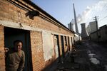A migrant worker in Beijing looks out from his lodging.