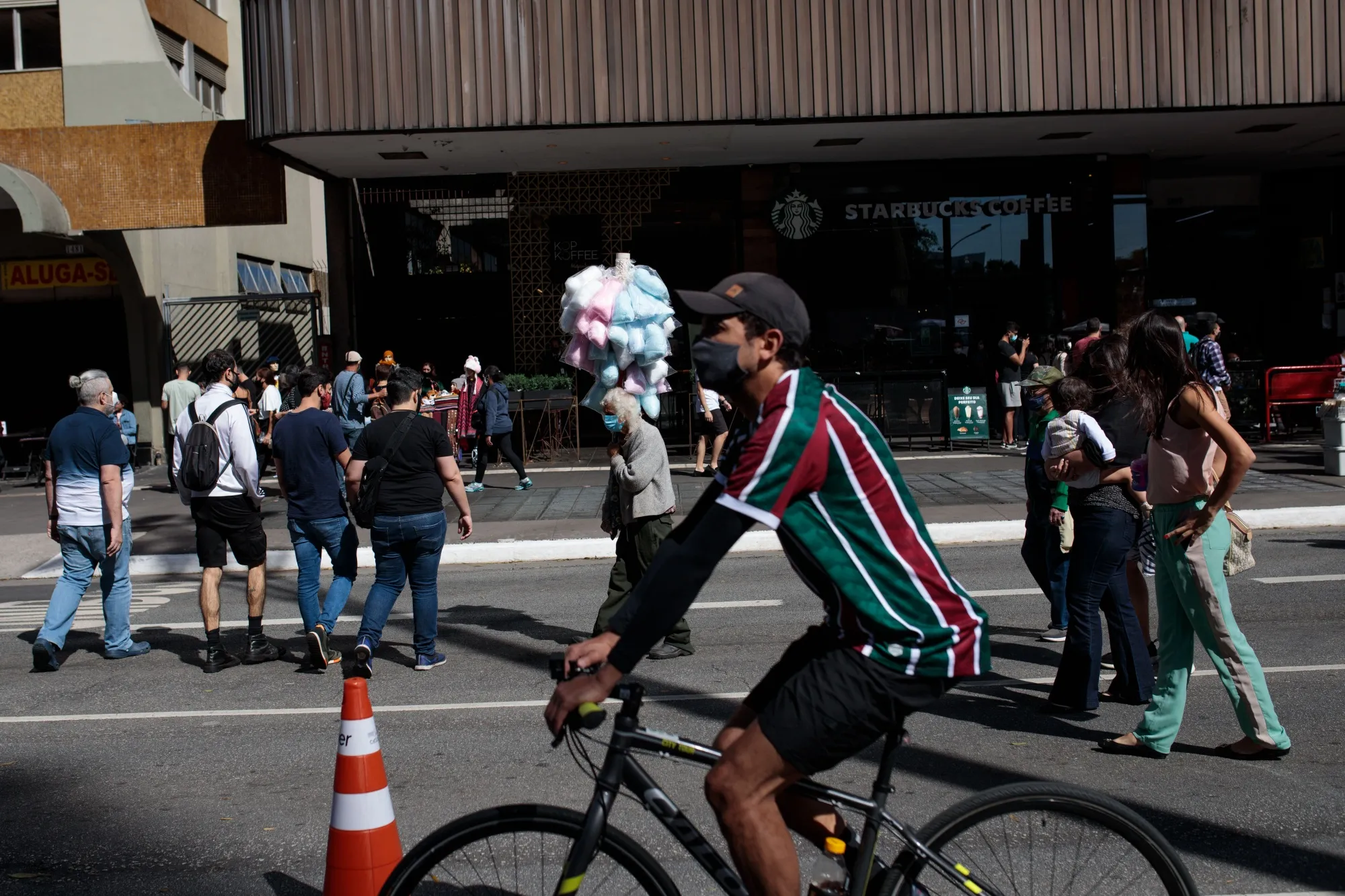 A cotton candy seller passes by visitors on Paulista Avenue&nbsp;in Sao Paulo, Brazil.